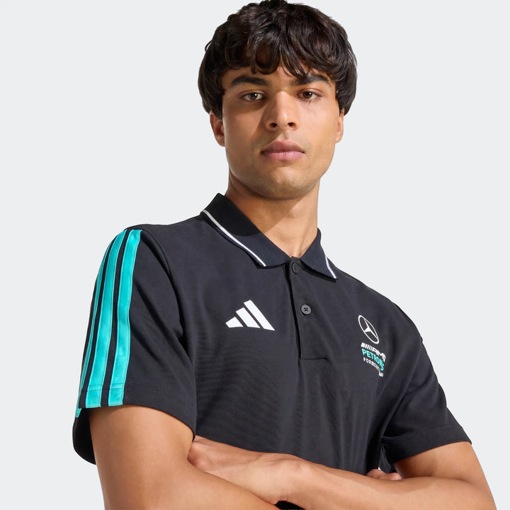Male model in a black Mercedes-AMG Petronas Formula 1 Team DNA Polo Shirt, featuring teal stripes on the sleeve and