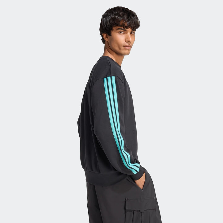 Male model wearing a black Mercedes-Amg Petronas Formula 1 Team Dna Sweatshirt with three blue stripes.