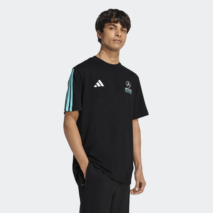 Male model wearing a black short-sleeved Mercedes-AMG Petronas Formula 1 Team DNA T-shirt in a studio setting.