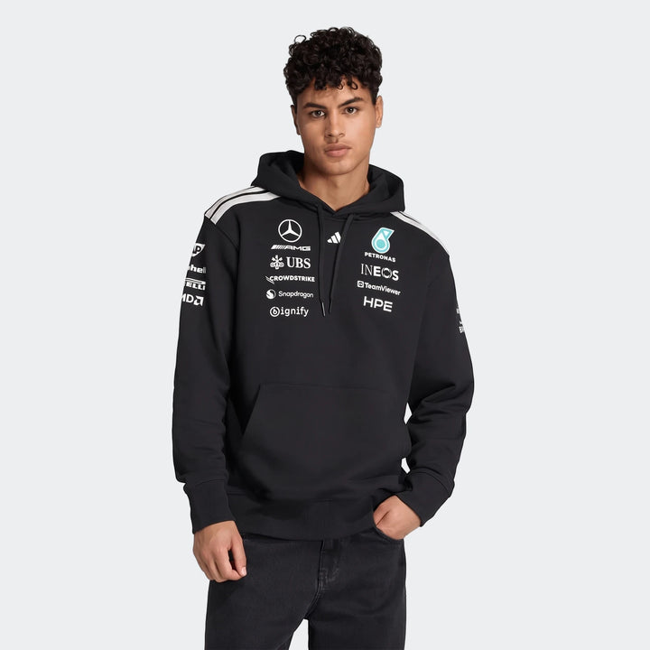 Black Mercedes-Amg Petronas Formula 1 Team Driver Hoodie worn by a man, detailed with sponsor logos.