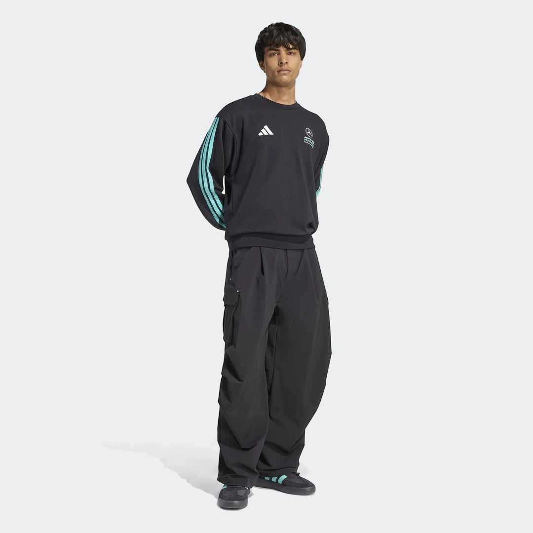Male model wearing a black Adidas Mercedes-AMG Petronas Formula 1 Team DNA Sweatshirt with turquoise stripes and black cargo
