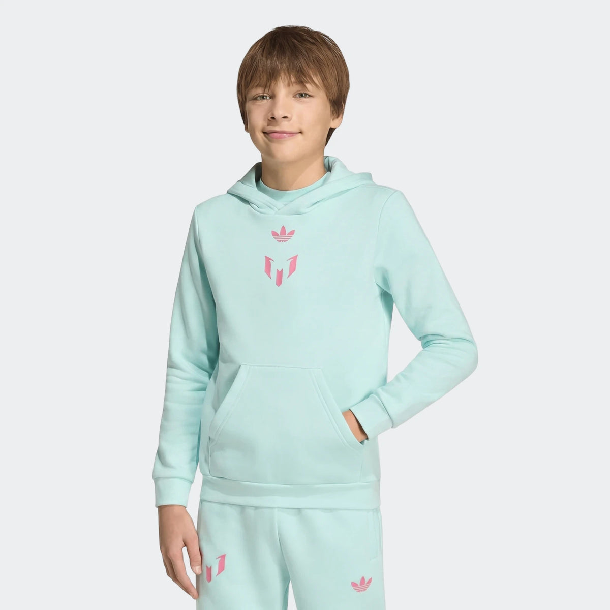 Light blue Messi Hoodie Youth and matching sweatpants worn by a boy, shown from mid-thigh up, standing with hand in pocket.