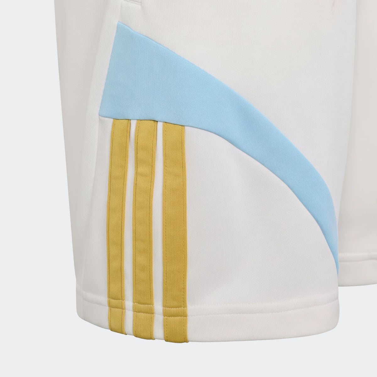 Close-up of Messi House Of Tiro Kids Shorts, white with light blue and yellow three-stripe details, highlighting the