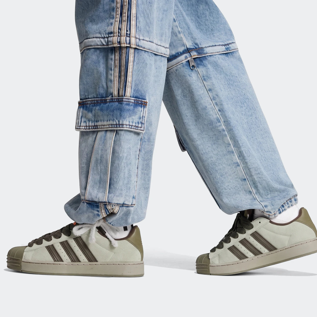 Close-up of a person walking in light blue Mid-Rise 2-In-1 Denim Pants with cargo pockets and green sneakers.