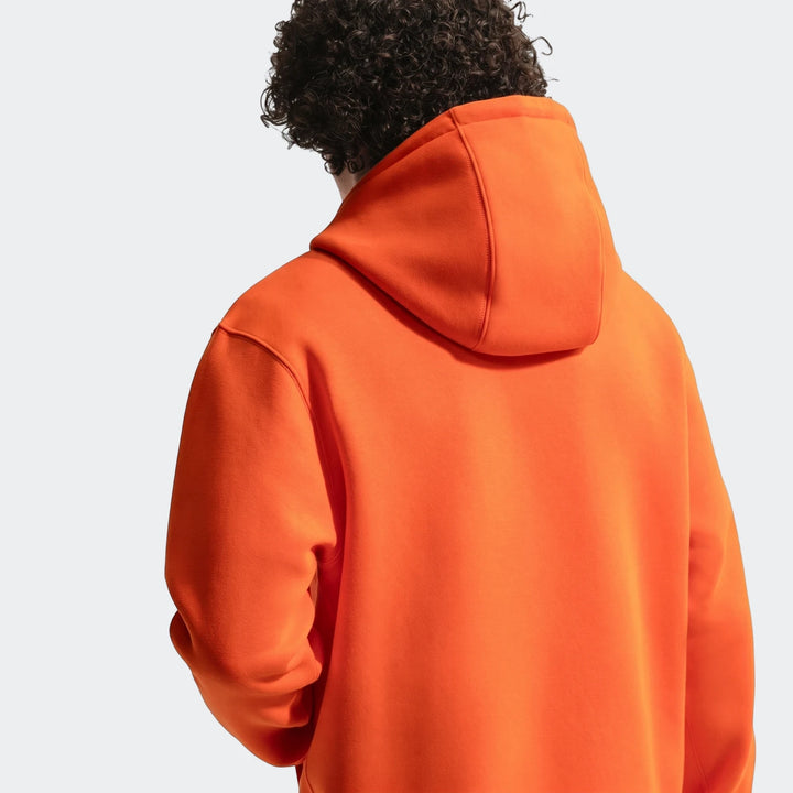 Netherlands Club orange men's Nike soccer pullover hoodie, seen from the back on a person with curly hair.