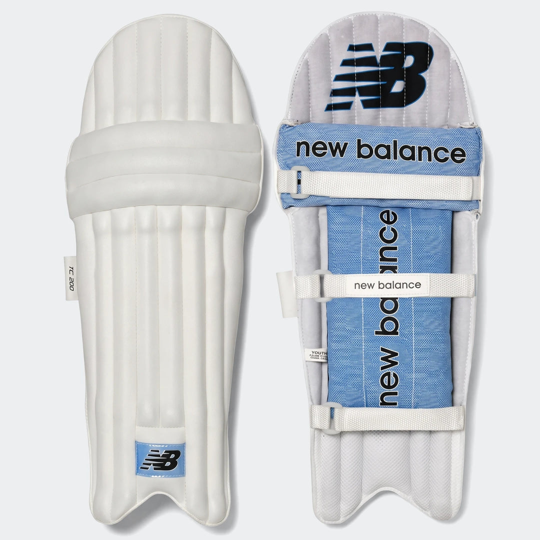 White New Balance TC200 junior cricket leg guards showing the front and padded blue interior with straps.