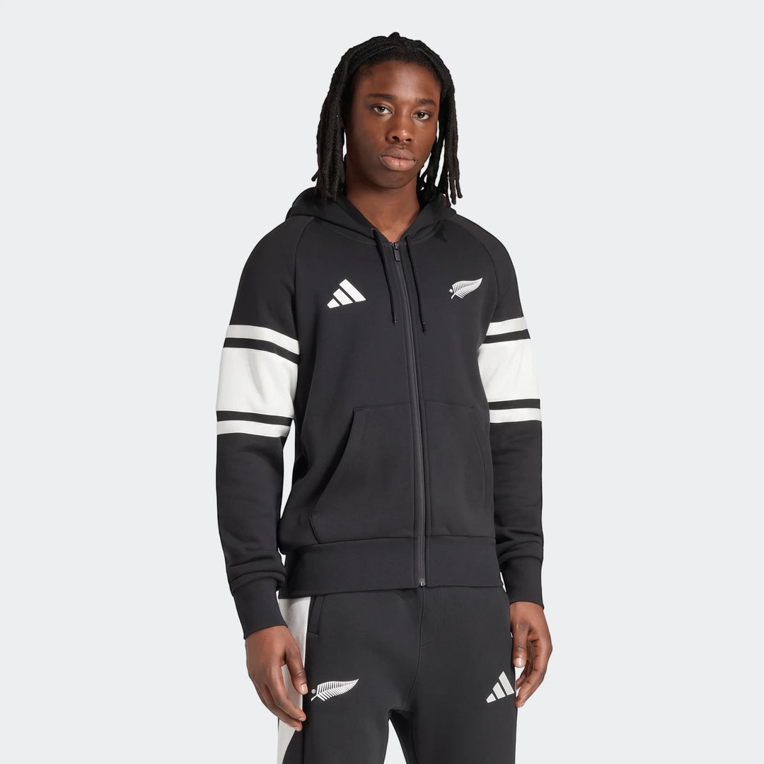 Men's black New Zealand Rugby leisurewear full zip hoodie with white stripes on sleeves, worn by a model.