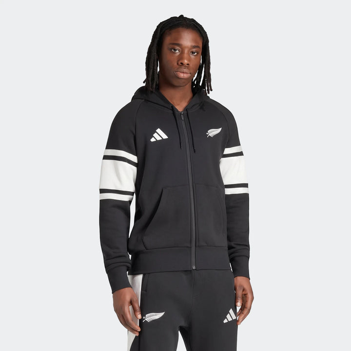 Men's black New Zealand Rugby leisurewear full zip hoodie with white stripes on sleeves, worn by a model.