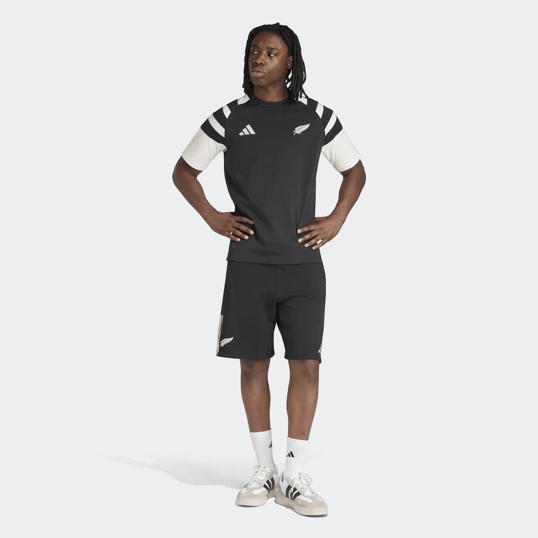 Men's New Zealand Rugby Leisurewear T-Shirt in black and off-white, paired with black shorts and white sneakers, worn by a