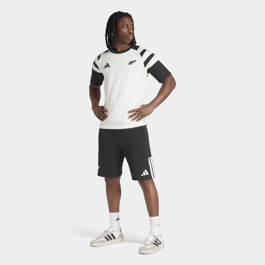 Men's New Zealand Rugby Leisurewear T-Shirt in white with black sleeves, paired with black shorts, modeled full-body.