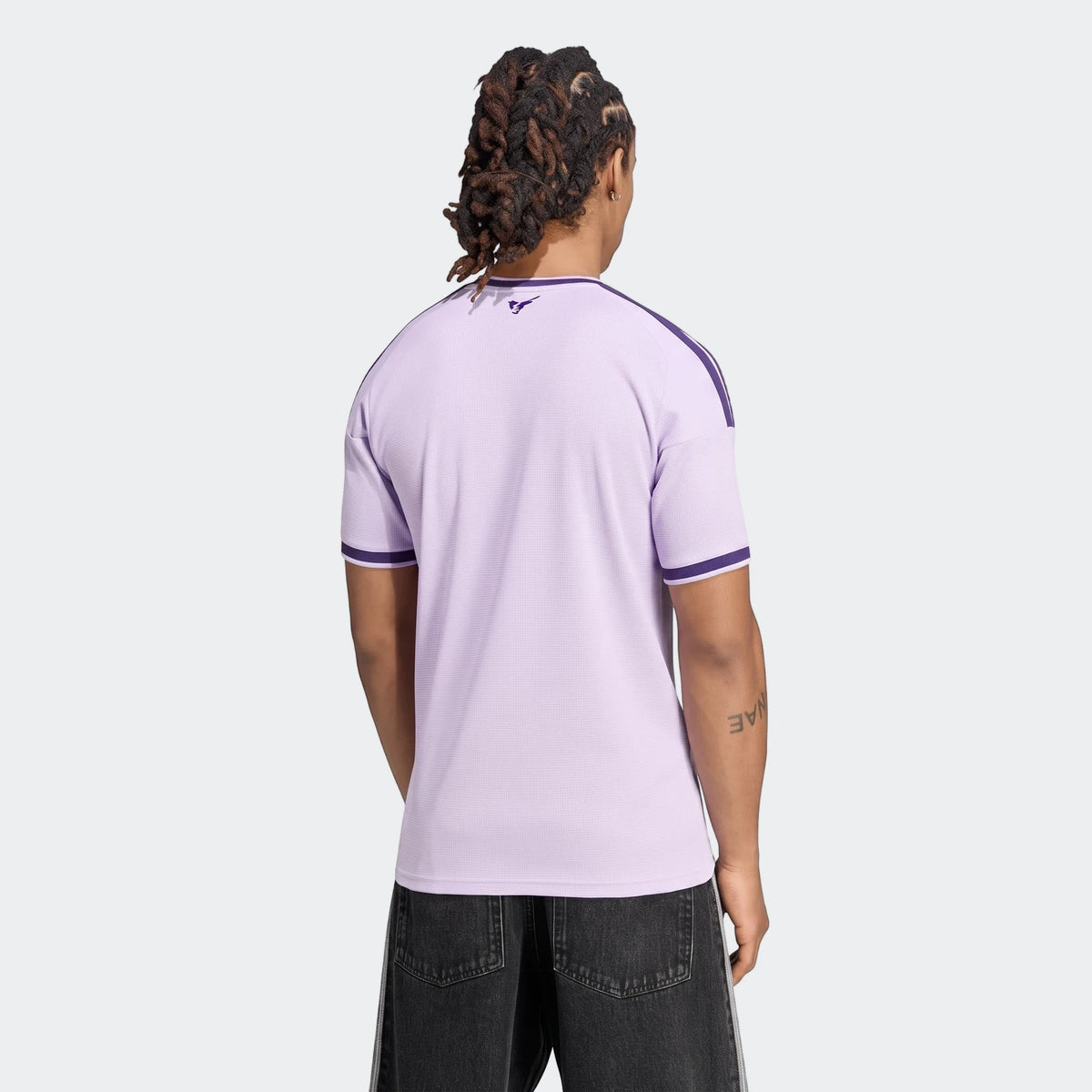Rear view of a male model wearing the light purple Newcastle United Fc 26/27 Third Jersey with dark stripes.