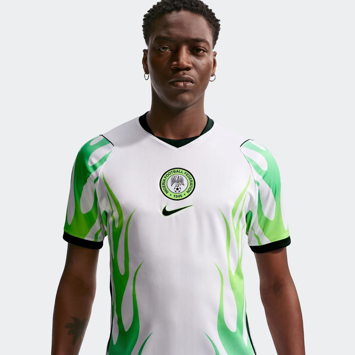 Nigeria 2026 Stadium Away Men's Nike Dri-Fit Soccer Replica Jersey in white with green flame graphics, worn by a male model.