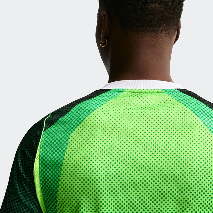 Man's back view, green Nike Dri-Fit Nigeria 2026 Stadium Home short-sleeve soccer jersey, showing mesh texture and a gold