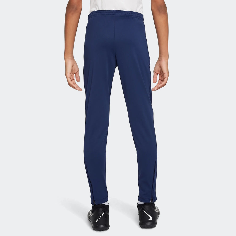 Navy blue Nike Academy Big Kids' Dri-Fit Soccer Pants, viewed from the back, showing elastic waistband and zippered ankles.
