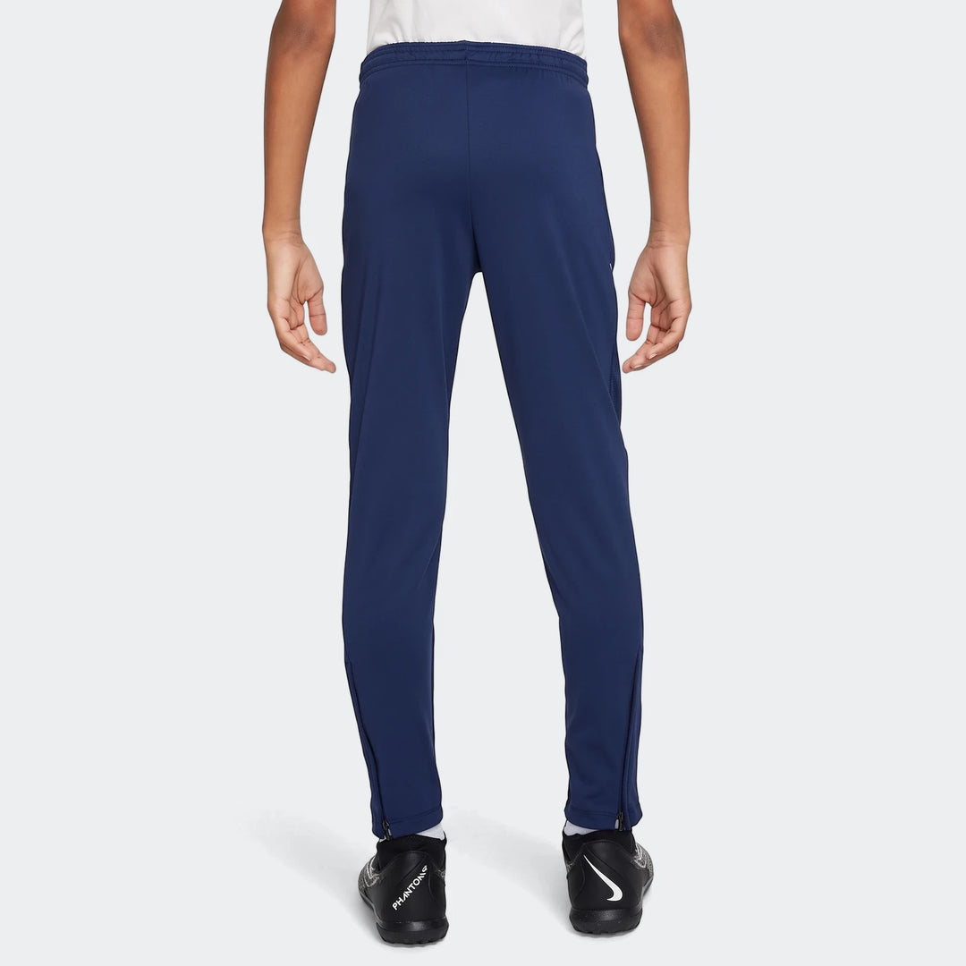 Navy blue Nike Academy Big Kids' Dri-Fit Soccer Pants, viewed from the back, showing elastic waistband and zippered ankles.