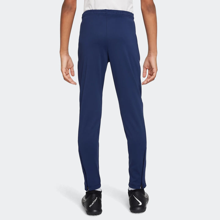 Navy blue Nike Academy Big Kids' Dri-Fit Soccer Pants, viewed from the back, showing elastic waistband and zippered ankles.
