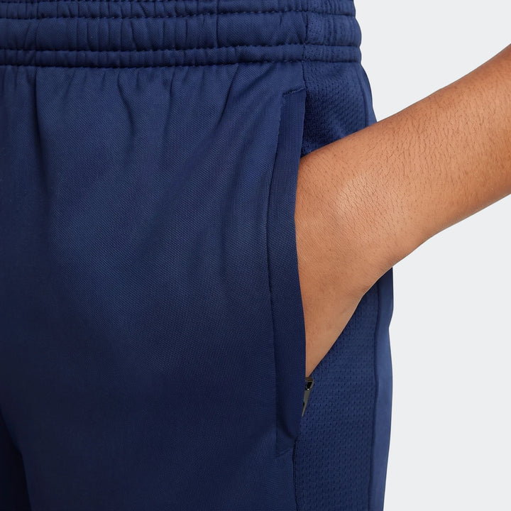 Close-up of Nike Academy Big Kids' Dri-Fit Soccer Pants in navy blue, showing the pocket with a hand inside, and mesh detail.