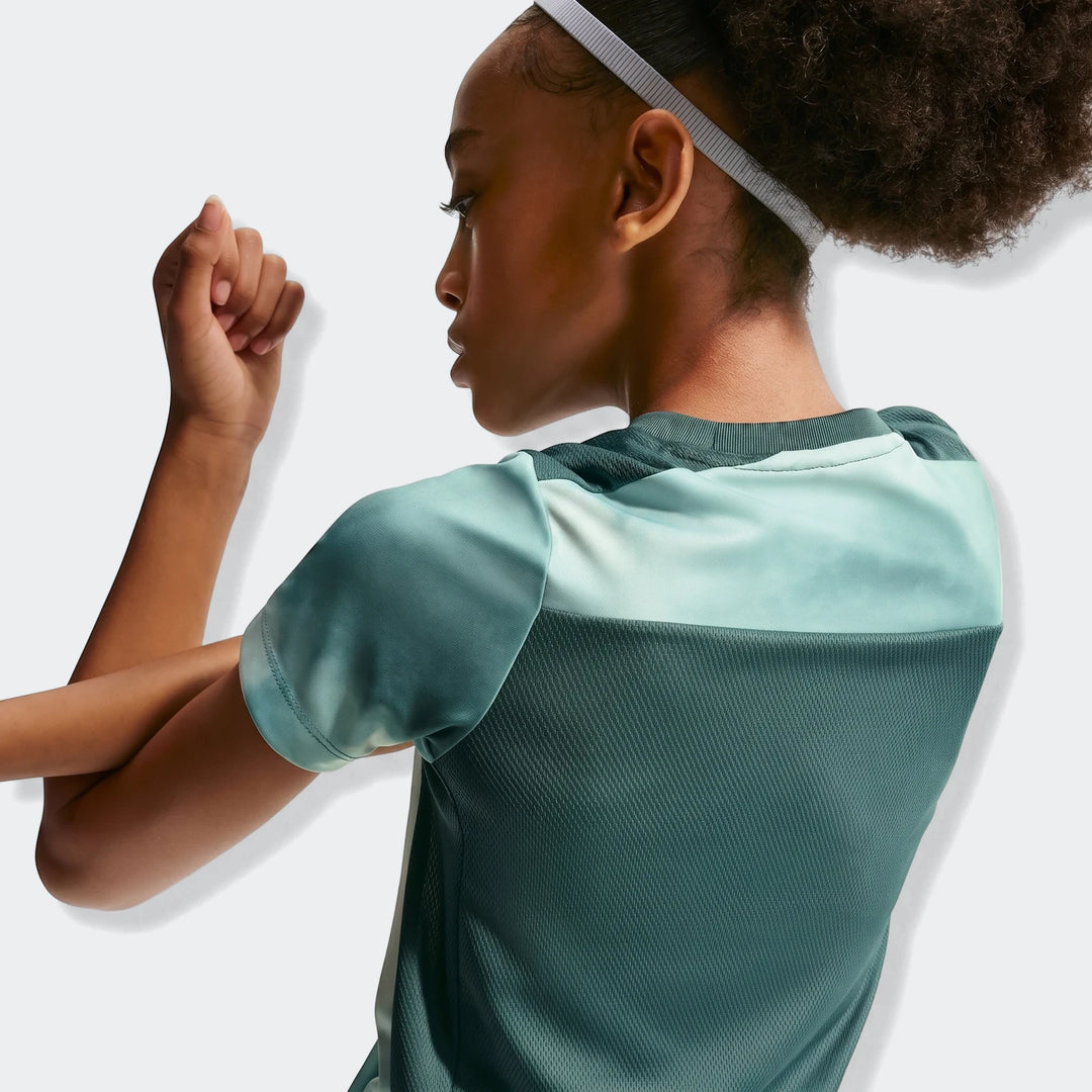 Nike Academy+ Green Big Kids' Dri-Fit Short-Sleeve Soccer Top worn by a young person, showcasing the two-tone green fabric
