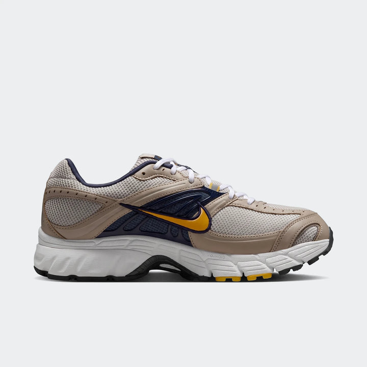 Nike Air Max Moto 2K 2Tone Men's Shoes in beige, navy, and yellow, captured in a dynamic side view.