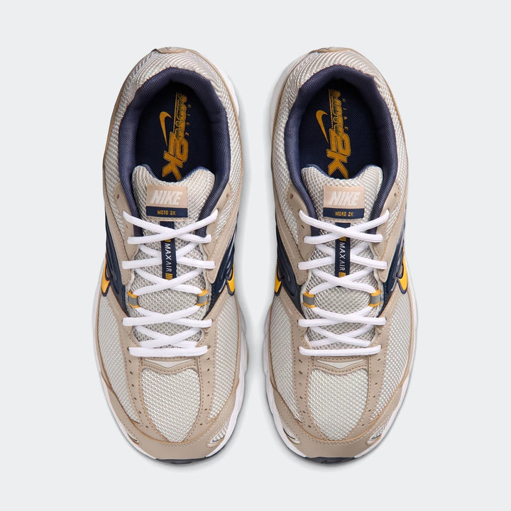 Top-down view of Nike Air Max Moto 2K 2Tone men's shoes in light beige, navy, and yellow, showcasing mesh and synthetic
