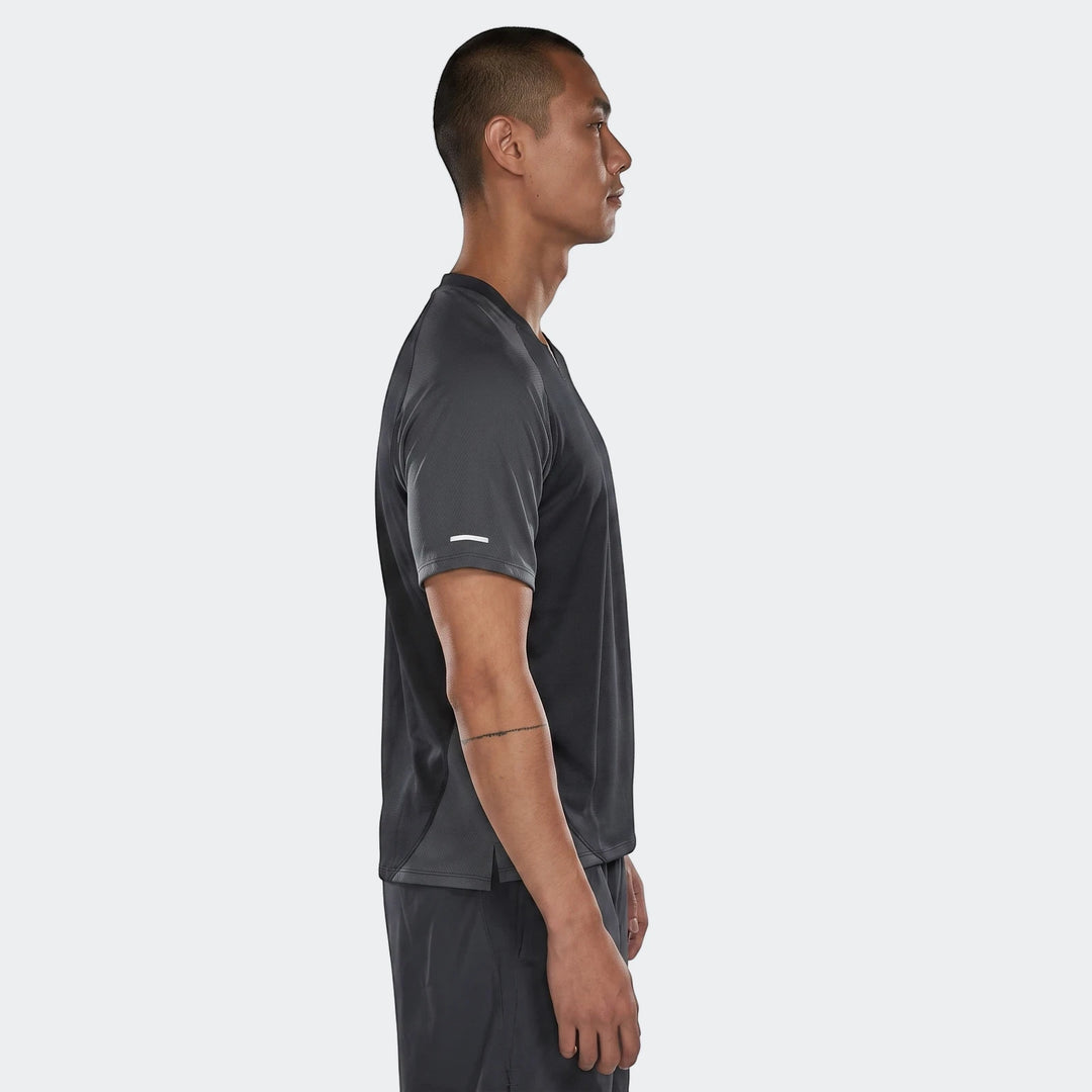 Nike Air men's dark grey short-sleeve top with a reflective stripe, worn by a man in profile, side view.