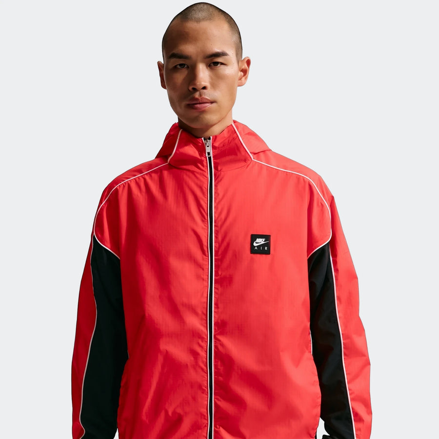 Nike Air men's full-zip hybrid utility jacket in red and black, worn by a model, featuring white piping details and a chest