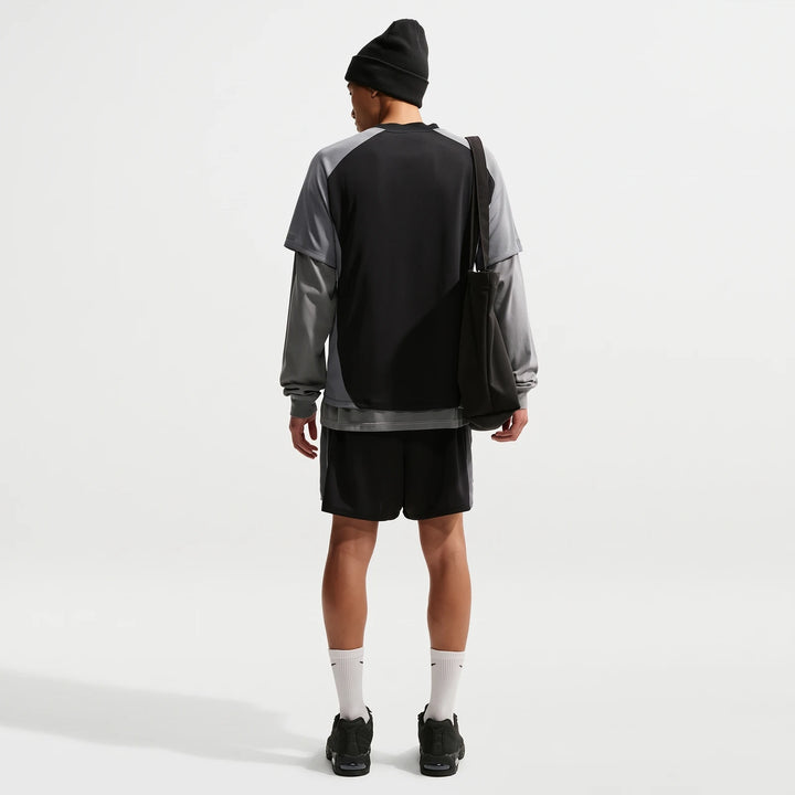 Nike Air Men's Top in black and grey, layered, styled with shorts and a beanie, viewed from the back.