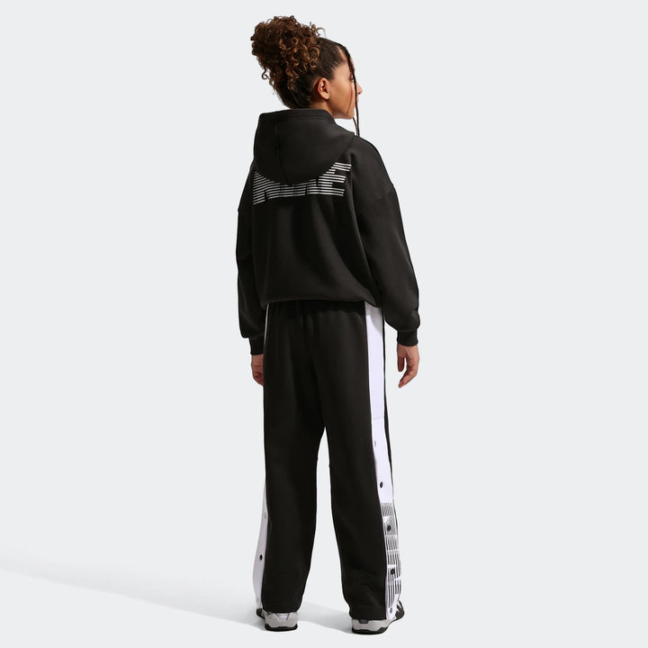Nike Big Kids' black basketball pants with white side stripes and a black hoodie, shown from the back on a model.