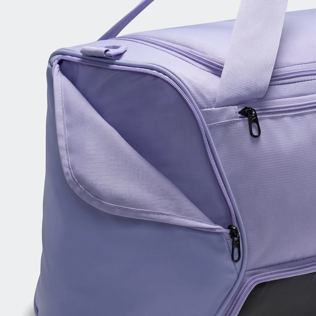 Close-up of a Nike Brasilia M Duffel Bag 9.5 in purple, showing an open side pocket with black zippers.