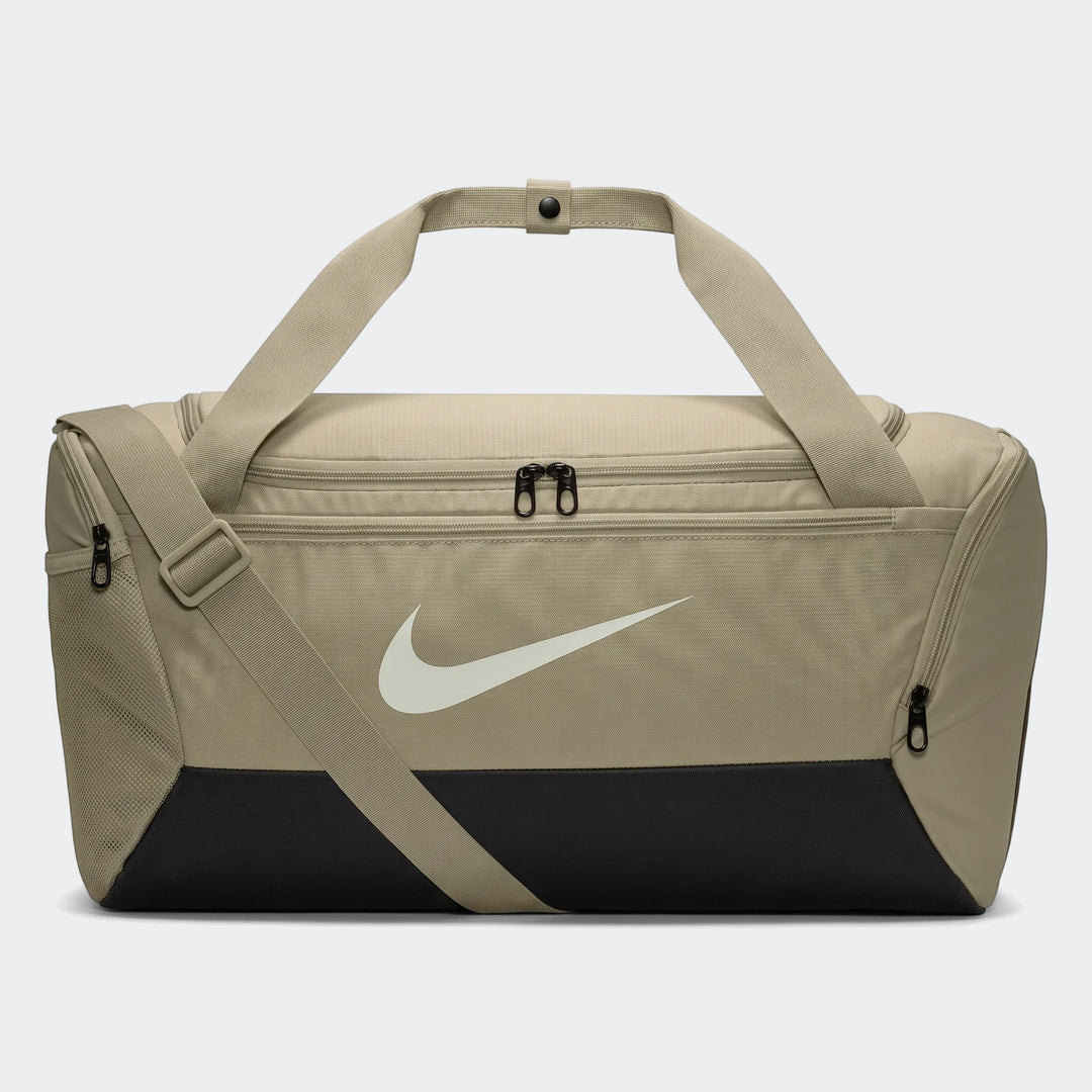 A brown Nike Brasilia 9.5 small duffel bag with black bottom panel, white swoosh logo, and shoulder strap, displayed on a