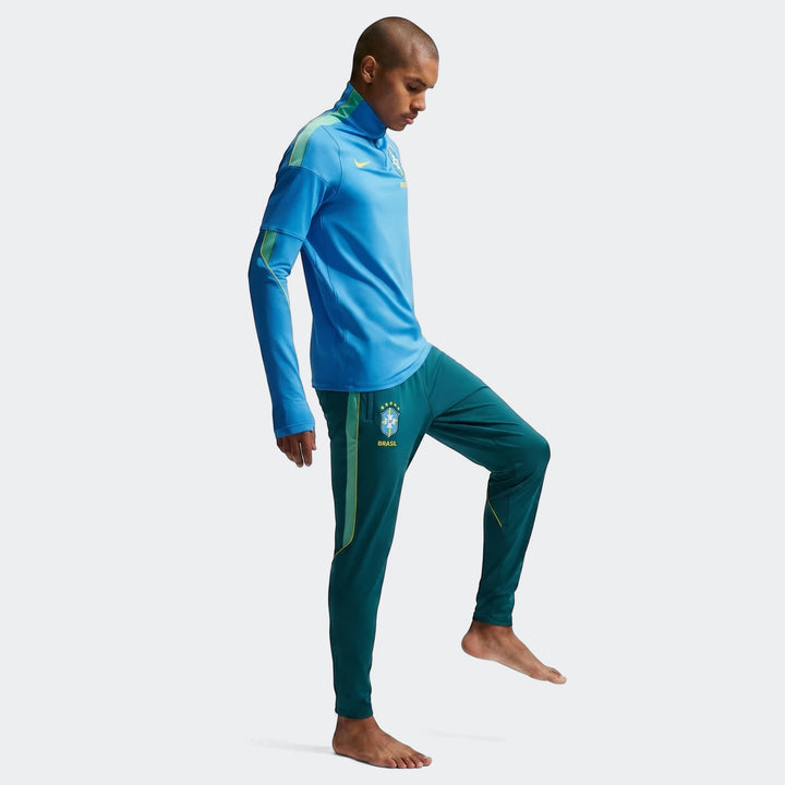 Men's Nike Brazil Strike Dri-Fit soccer knit pants in dark green, featuring team crest and yellow accents.