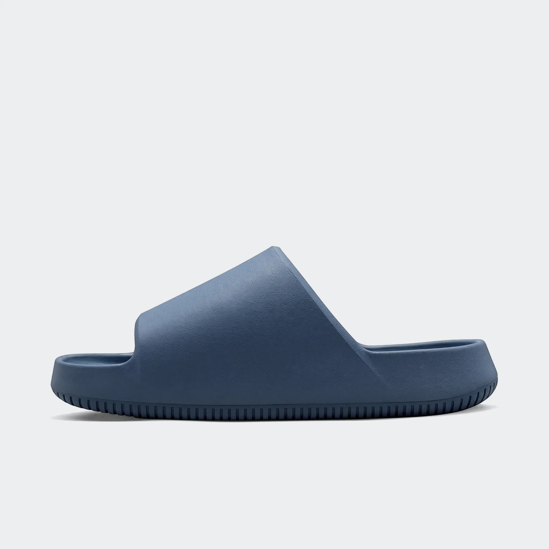 Blue Nike Calm 2.0 Men's Slides in a side profile, showcasing the textured strap and ridged sole for casual wear.