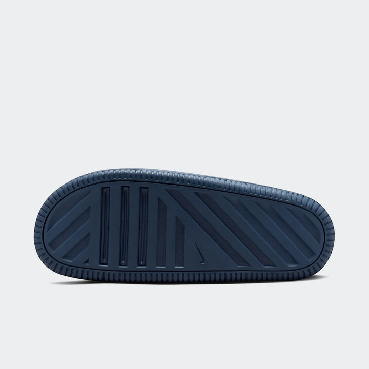 Nike Calm 2.0 Men's Slides in dark blue, showcasing the textured sole with grip patterns. View from the bottom.