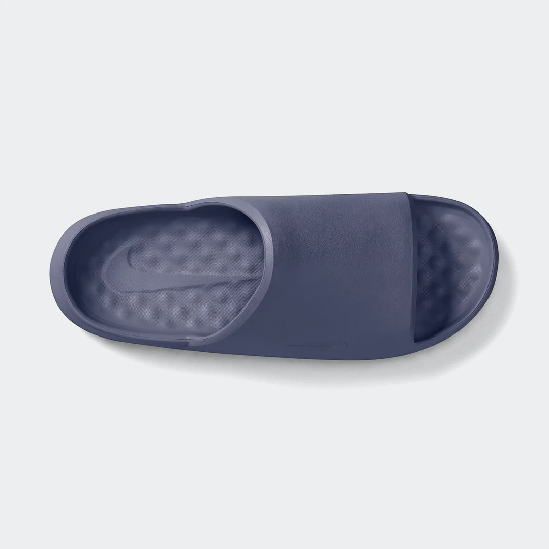 Top-down view of a single dark blue Nike Calm 2.0 Men'S Slide, featuring a textured footbed with an embossed Swoosh logo.