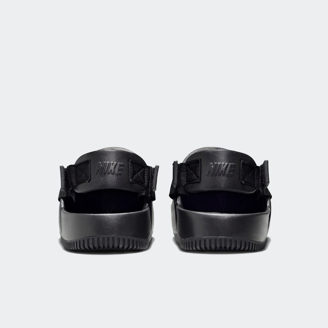 Back view of black Nike Calm men's mules featuring a ribbed sole and embossed Nike logo on the strap, against a white