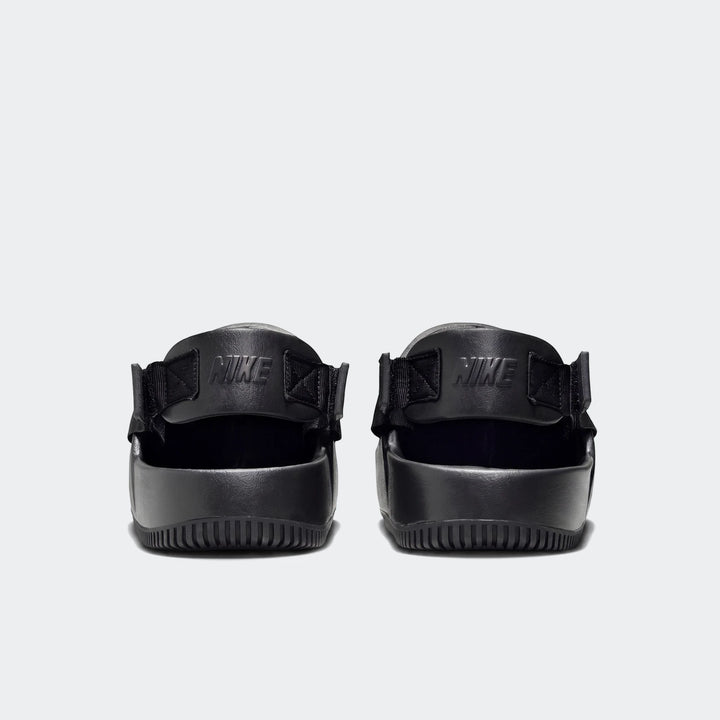 Back view of black Nike Calm men's mules featuring a ribbed sole and embossed Nike logo on the strap, against a white