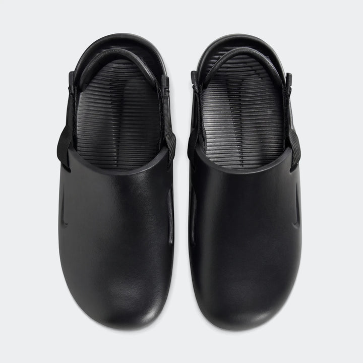 Pair of black Nike Calm men's mules, showcasing the top-down view of the smooth rubber-like material and textured footbed.
