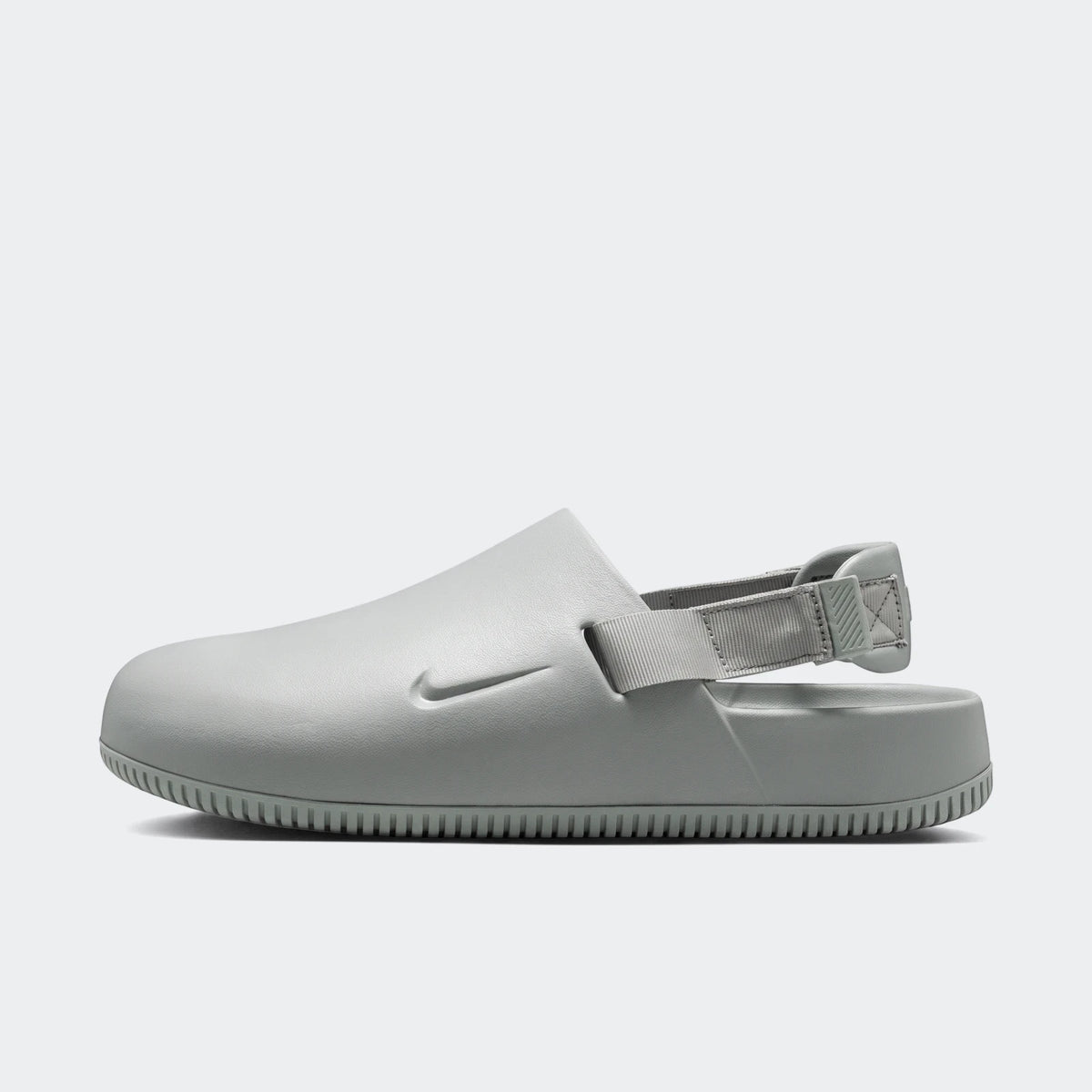 Nike Calm Men's Mules in light grey, shown in a side profile view, highlighting the ergonomic design and textured sole.