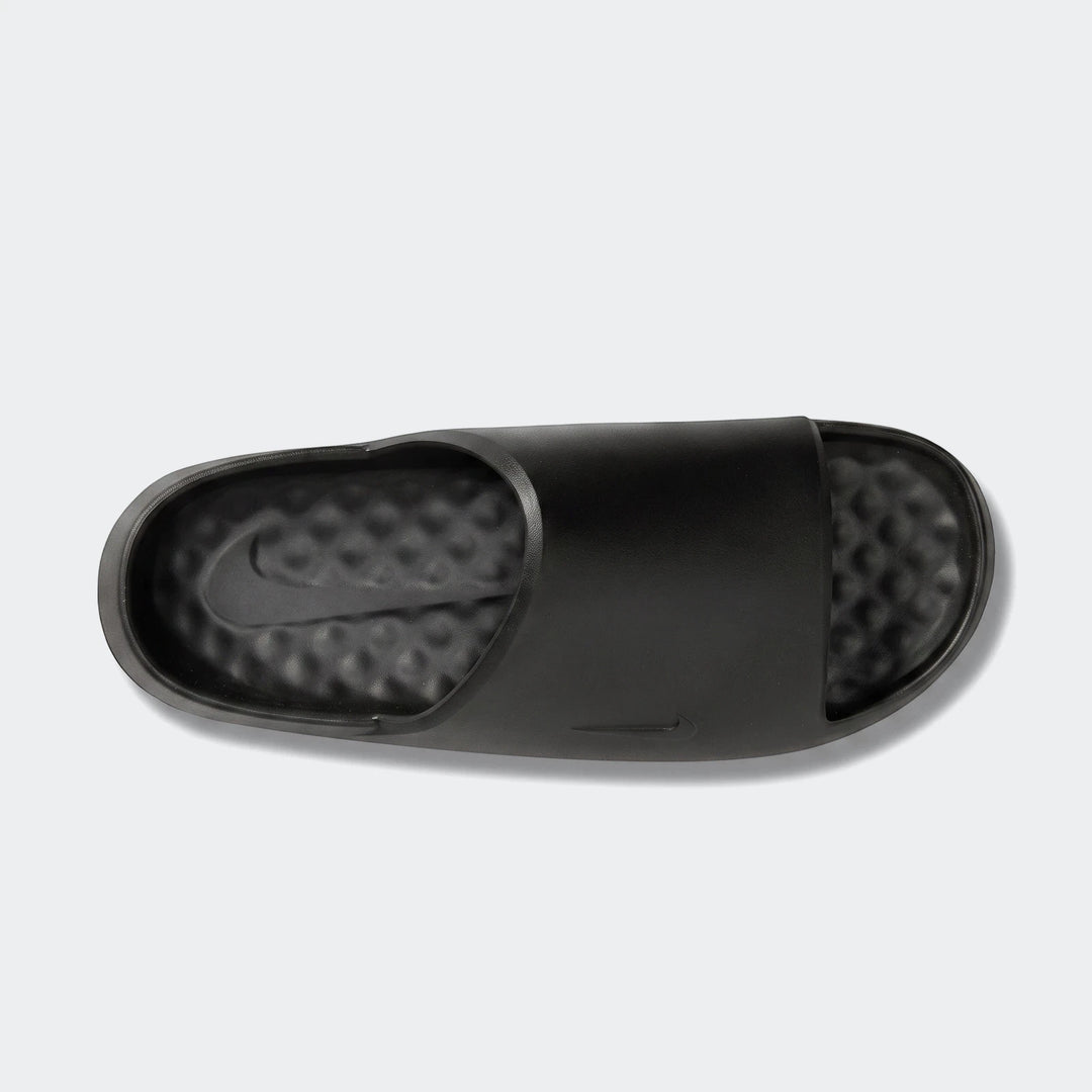 Nike Calm Slide 2.0 black rubber slides, viewed from above on a white background, featuring a textured footbed and sleek