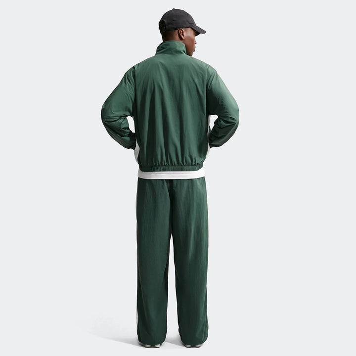 Nike Club Men's 1/2 Zip Jacket in green, paired with matching track pants, modeled from the back on a white background.