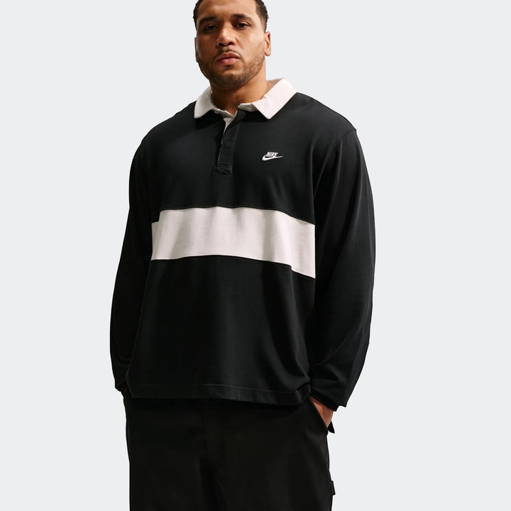 Nike Club Men's Long-Sleeve Rugby Top in black and white, worn by a male model, featuring a classic collar and Nike logo.