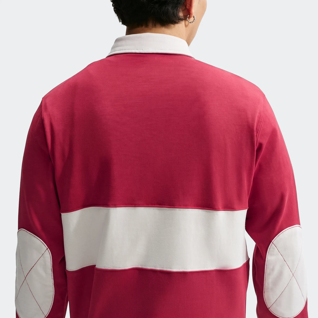 Red and white Nike Club Men's Long-Sleeve Rugby Top, back view, featuring white collar, horizontal stripe, and elbow patches.