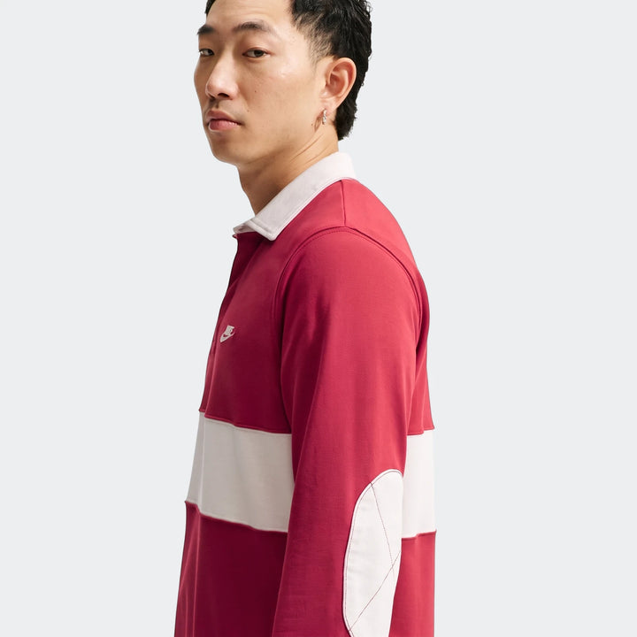 Men's red and white striped Nike Club long-sleeve rugby top, featuring a white collar and elbow patches, worn by a male