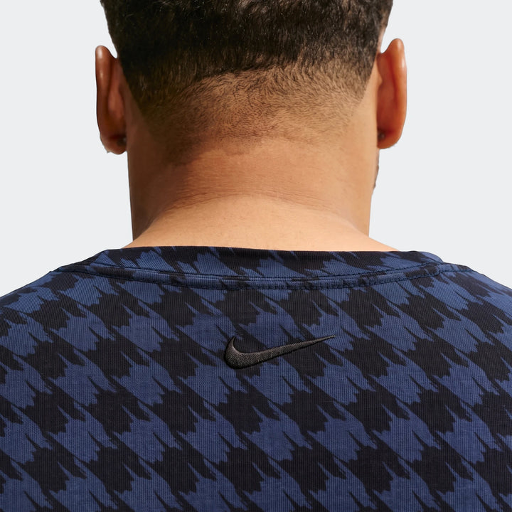 Back view of a person wearing a Nike Club Rules T-Shirt in blue and black houndstooth pattern.