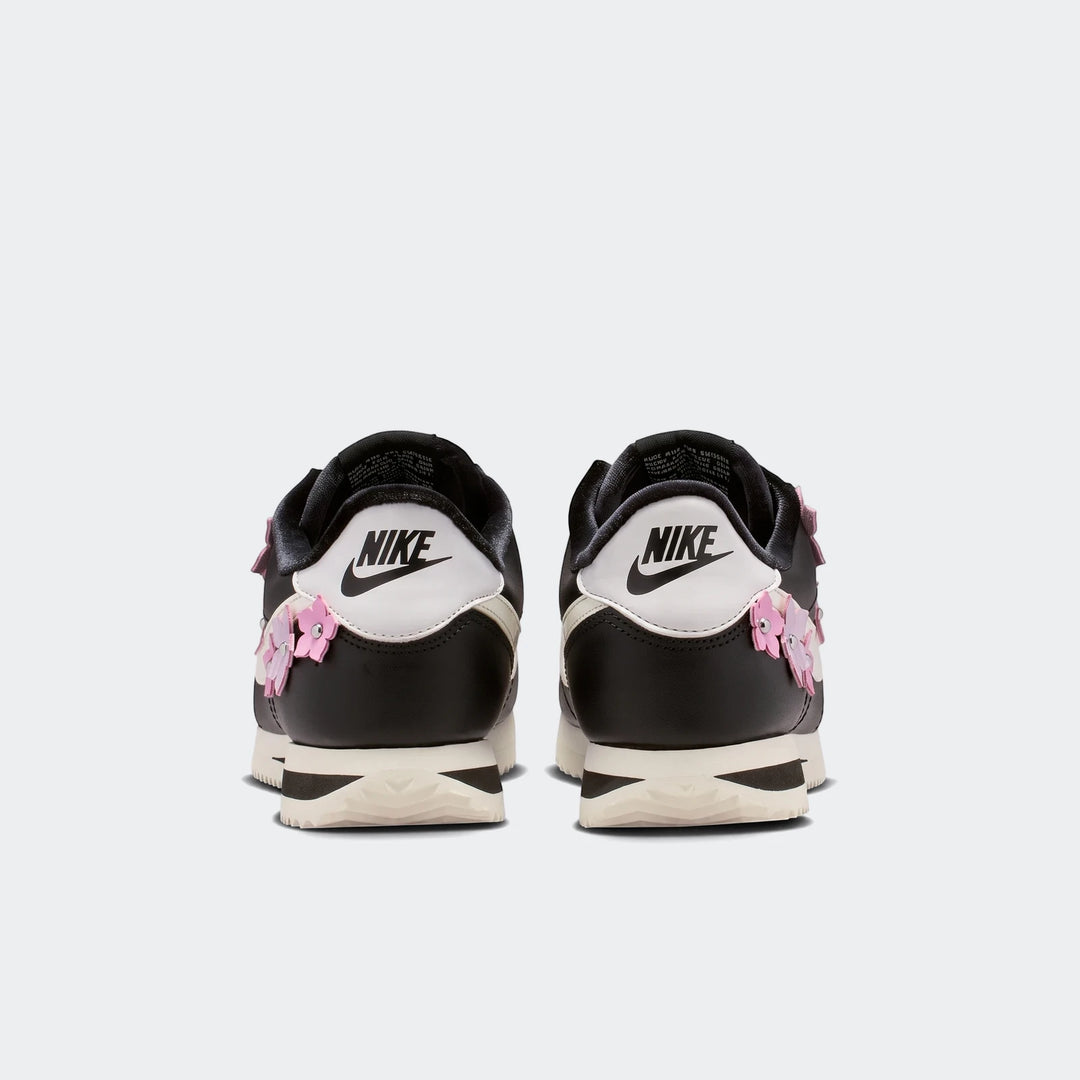 Nike Cortez Leather Women's Shoes in black and white with pink floral details, presented in a rear view.