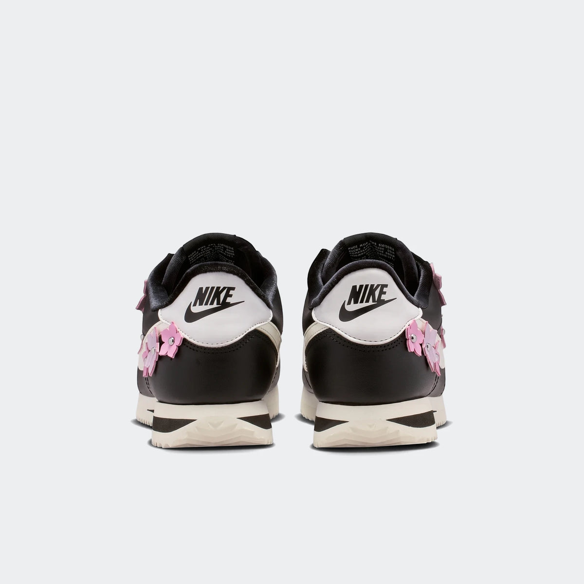 Nike Cortez Leather Women's Shoes in black and white with pink floral details, presented in a rear view.