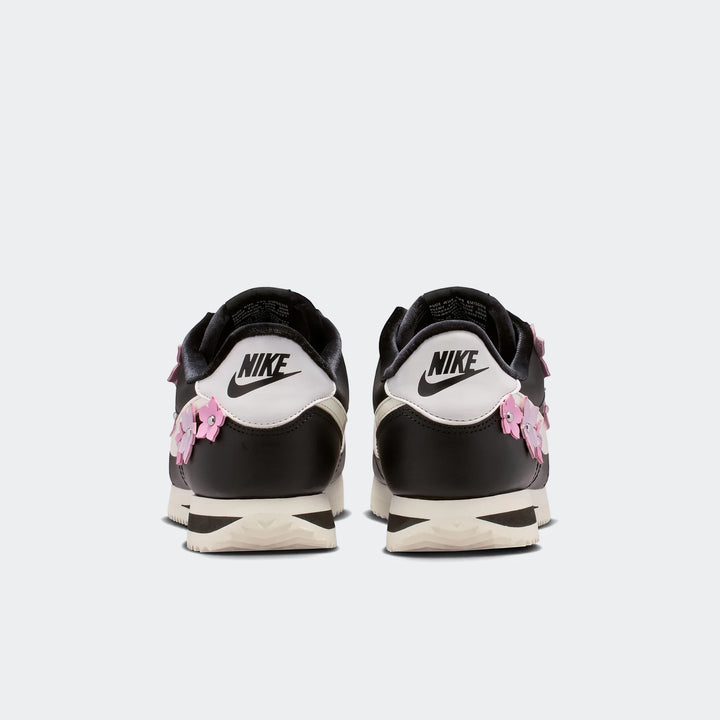 Nike Cortez Leather Women's Shoes in black and white with pink floral details, presented in a rear view.