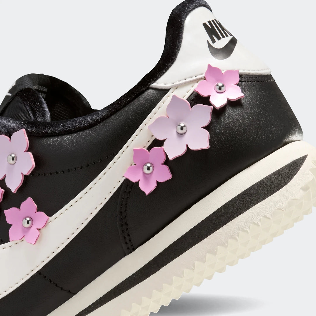 Nike Cortez Leather Women's Shoes in black and white with pink floral embellishments, close-up side view.