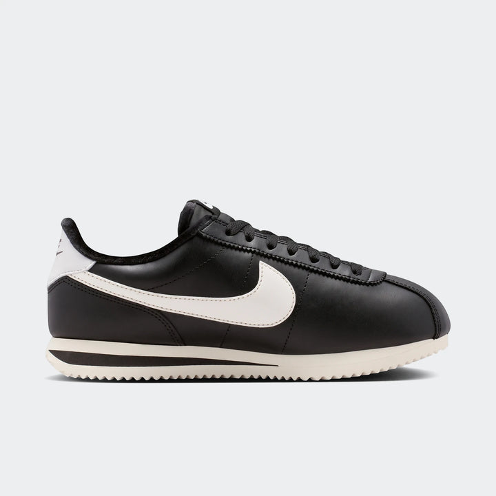 Black and white Nike Cortez Leather Women's Shoes, captured in a clean side profile, showcasing the classic design.