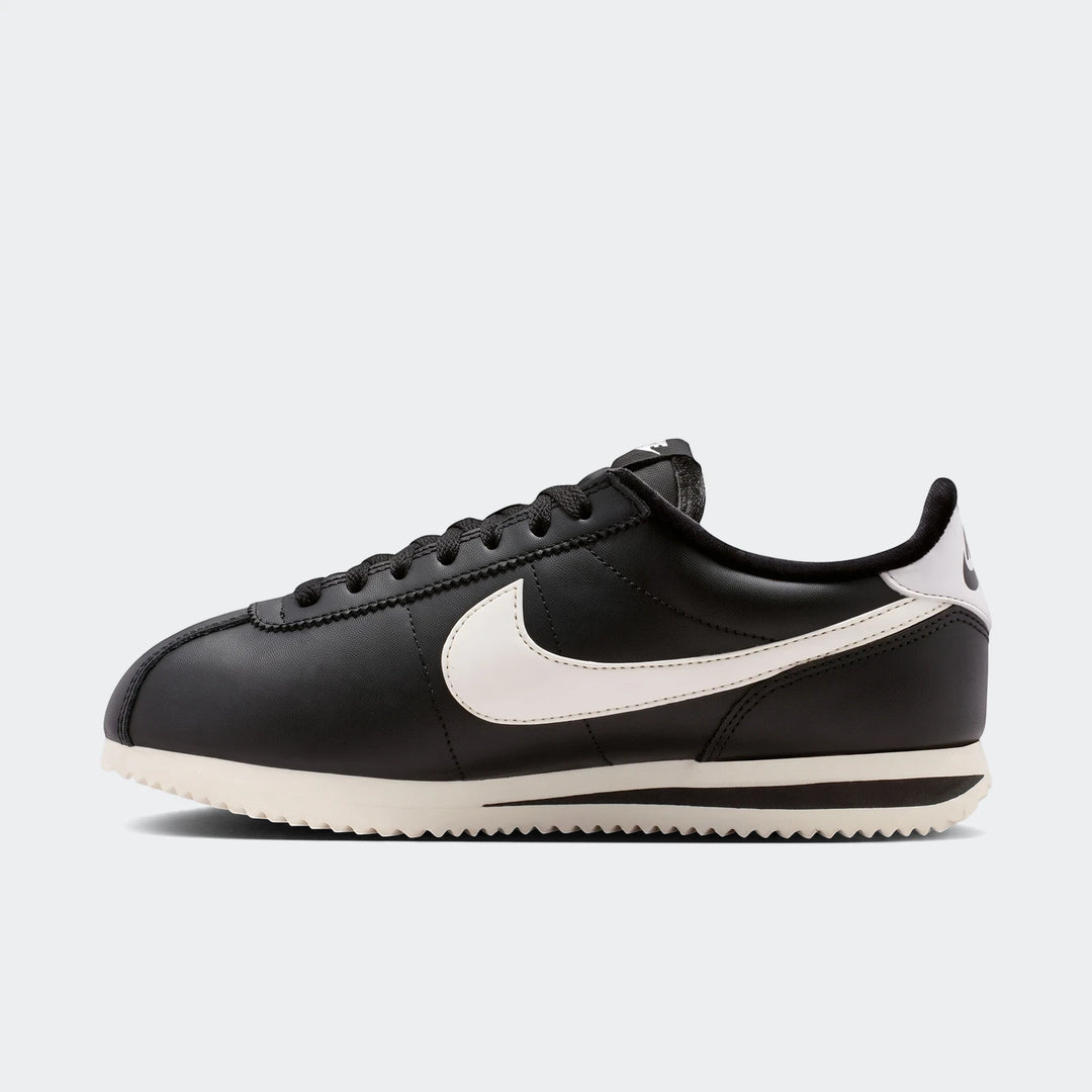 Black Nike Cortez Leather Women's Shoes with white swoosh, side view on a clean background.